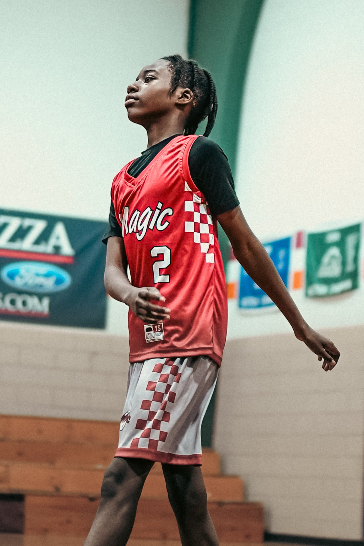 Person wearing a red basketball jersey with 'Magic' and number '2' on a sports court.